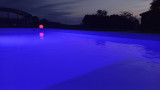 Piscine dans la douceur d'une nuit d'été avec toit ouvert